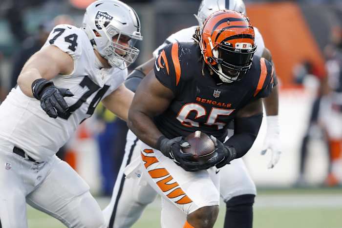 Jan 15, 2022; Cincinnati, Ohio, USA; Cincinnati Bengals defensive tackle Larry Ogunjobi (65) picks up the fumble as Las Vegas Raiders offensive tackle Kolton Miller (74) goes for the tackle during the first quarter in an AFC Wild Card playoff football game at Paul Brown Stadium. Mandatory Credit: Joseph Maiorana-USA TODAY Sports